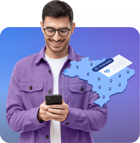 Imagem de um rapaz, sorrindo e de frente, mexendo no aplicativo Vale Saúde pelo celular